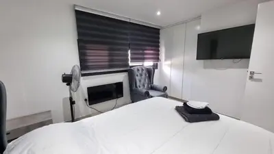 a bedroom with a bed and a tv and a chair at Nagia’s Apartment in Kakopetria