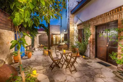 a patio with a table and chairs and plants at Oinoessa Traditional Boutique Guest Houses in Lofou