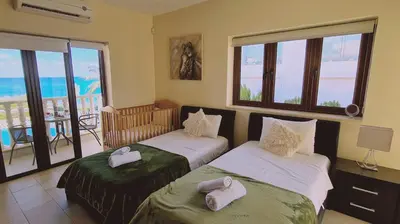 two beds in a room with a view of the ocean at STAY Ocean View Villa in Paralimni