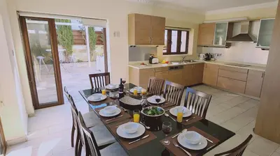a dining room with a table and chairs in a kitchen at STAY Ocean View Villa in Paralimni