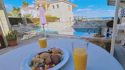 a plate of food on a table with two glasses of orange juice at STAY Ocean View Villa in Paralimni
