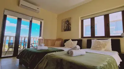 two beds in a room with windows and a balcony at STAY Ocean View Villa in Paralimni
