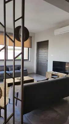 a living room with a black couch and a ladder at Hanna Panorama Villa in Protaras