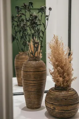 three vases with flowers in them on a table at The Green Apartment in Larnaka