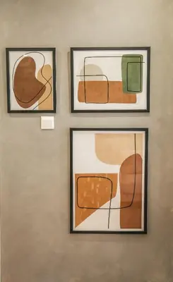 three framed paintings on a wall in a room at The Green Apartment in Larnaka