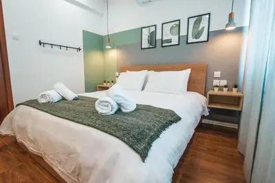 a bedroom with a large bed with towels on it at The Green Apartment in Larnaka