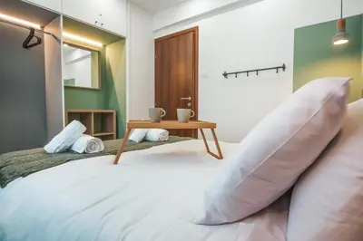 a bedroom with a bed with pillows and a table at The Green Apartment in Larnaka