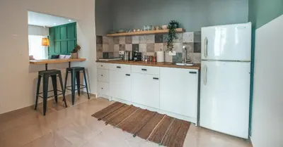 a kitchen with white cabinets and a white refrigerator at The Green Apartment in Larnaka