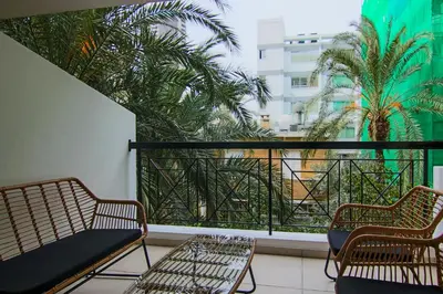 a balcony with two chairs and a balcony with palm trees at Phaedrus Living City View Luxury Iras Flat 102 in Nicosia
