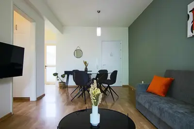 a living room with a couch and a table with chairs at Phaedrus Living City View Luxury Iras Flat 102 in Nicosia