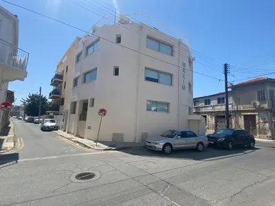 two cars parked in front of a white building at Appartments in the historic center near beach in Limassol