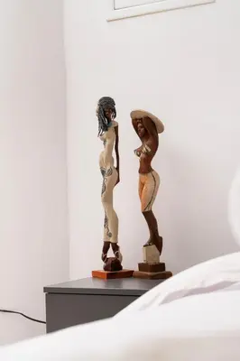 a couple of statues sitting on a table next to a bed at Appartments in the historic center near beach in Limassol