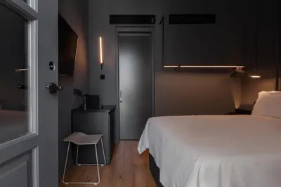 a bedroom with a bed and a chair next to a door at The Sendal Boutique Hotel in Nicosia