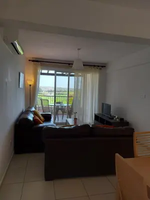 a living room with a couch and a table at Pyla Palms Resort - 1 bedroom in Pyla
