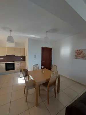 a kitchen and dining room with a wooden table and chairs at Pyla Palms Resort - 1 bedroom in Pyla