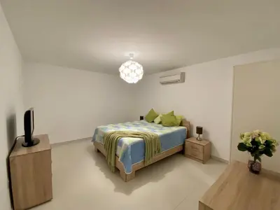 a bedroom with a bed and a tv and a table at Villa Kapparis Sunrise in Paralimni