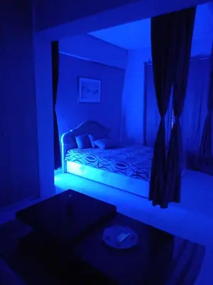 a dark room with a bed with a blue light at Old Town studio apartment in Larnaka