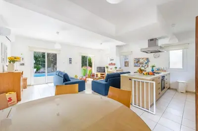 a kitchen and living room with a table and chairs at Protaras Villa Athamas Blue in Protaras