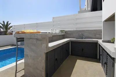 a kitchen with a sink and a pool at Villa Queen Valeria in Protaras