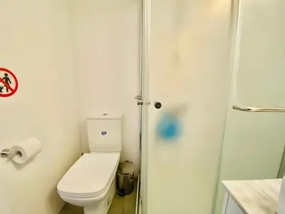 a bathroom with a toilet and a shower at Panoramic Seaside Getaway, 2-BR Penthouse in Larnaka