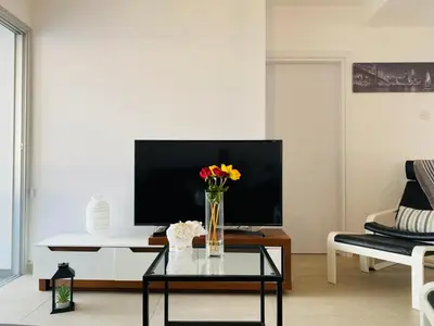 a living room with a vase of flowers on a table at Panoramic Seaside Getaway, 2-BR Penthouse in Larnaka