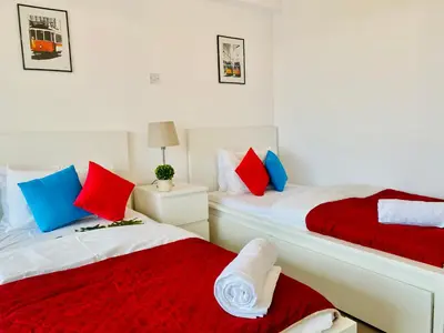 two beds in a room with red and blue pillows at Panoramic Seaside Getaway, 2-BR Penthouse in Larnaka