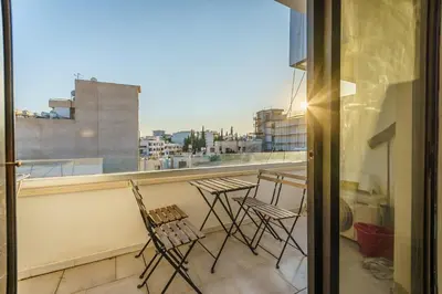 a balcony with chairs and a view of a city at Fanta Sea Apartment in Larnaka