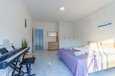 a bedroom with a bed and a desk with a keyboard at Fanta Sea Apartment in Larnaka