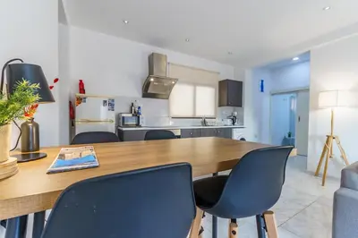 a kitchen and dining room with a wooden table and chairs at Fanta Sea Apartment in Larnaka