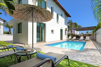 a villa with a swimming pool and an umbrella at Villa Levandini in Protaras