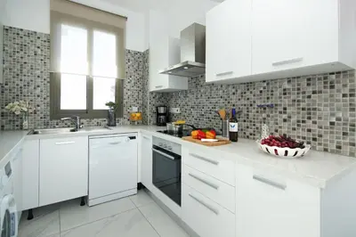 a white kitchen with white cabinets and a bowl of fruit at Villa Levandini in Protaras