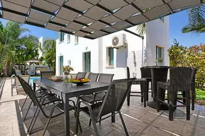 a patio with a table and chairs and a grill at Villa Levandini in Protaras