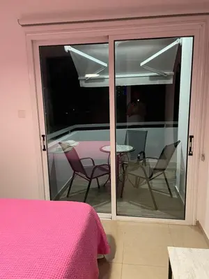 a bedroom with a balcony with a table and chairs at Cyprus Penelope in Larnaka