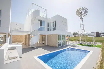 a villa with a swimming pool and a windmill at Vie Bleu 3 Bedroom Villas in Protaras