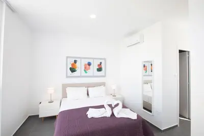 a white bedroom with a bed with a swan on it at Vie Bleu 3 Bedroom Villas in Protaras