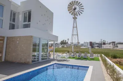 a house with a pool and a windmill at Vie Bleu 3 Bedroom Villas in Protaras