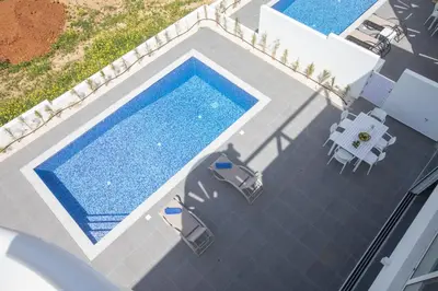 an overhead view of a swimming pool with a table and chairs at Vie Bleu 3 Bedroom Villas in Protaras