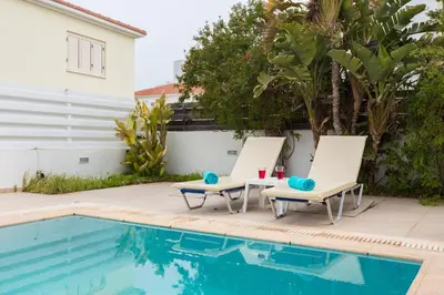 two chairs sitting next to a swimming pool at Pernera Holiday Villa 588 in Paralimni