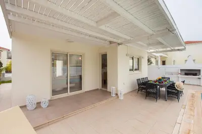 a patio with a table and chairs and a ceiling at Pernera Holiday Villa 588 in Paralimni