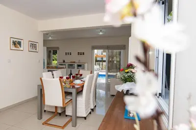 a dining room and kitchen with a table and chairs at Villa Helena in Ayia Napa