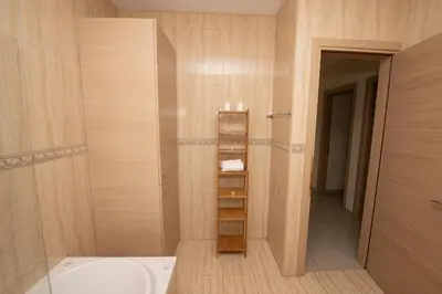 a bathroom with a toilet and a sink and a shelf at Villa Helena in Ayia Napa