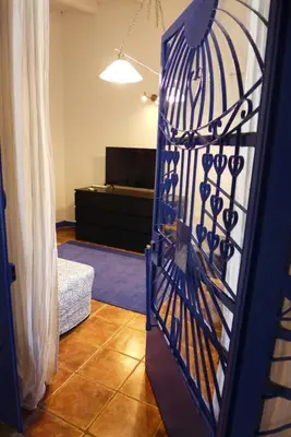 a living room with a blue iron door with a couch at Kalimera A Lovely 1-bedroom rental with ensuite and Kitchen in Limassol