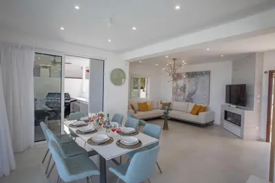 a dining room and living room with a table and chairs at Artizan Seafront Villa 5 in Protaras