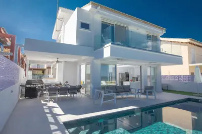 a villa with a swimming pool and a house at Artizan Seafront Villa 5 in Protaras