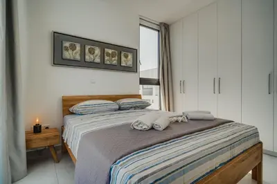a bedroom with a bed with two towels on it at SunnyVillas 4BR New Villa Private Pool in Pernera in Protaras