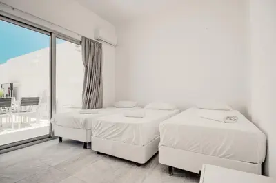 two beds in a white room with a window at SunnyVillas 4BR New Villa Private Pool in Pernera in Protaras