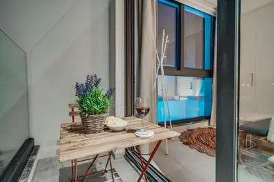 a table with a glass of wine and a plant at SunnyVillas 4BR New Villa Private Pool in Pernera in Protaras