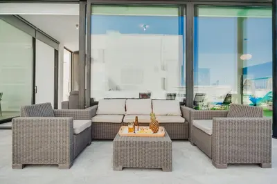 a patio with wicker chairs and a table at SunnyVillas 4BR New Villa Private Pool in Pernera in Protaras