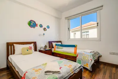 a bedroom with a bed and a chair and a window at Villa Emily in Protaras