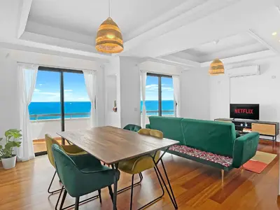 a dining room with a table and chairs and the ocean at 180° SEAVIEW Apt. right on famous beach promenade in Larnaka
